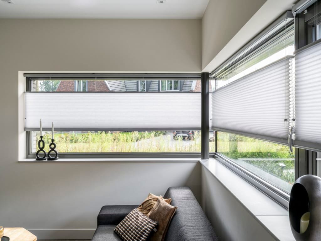 Duette plissé in een hoekraam van een lichte woonkamer