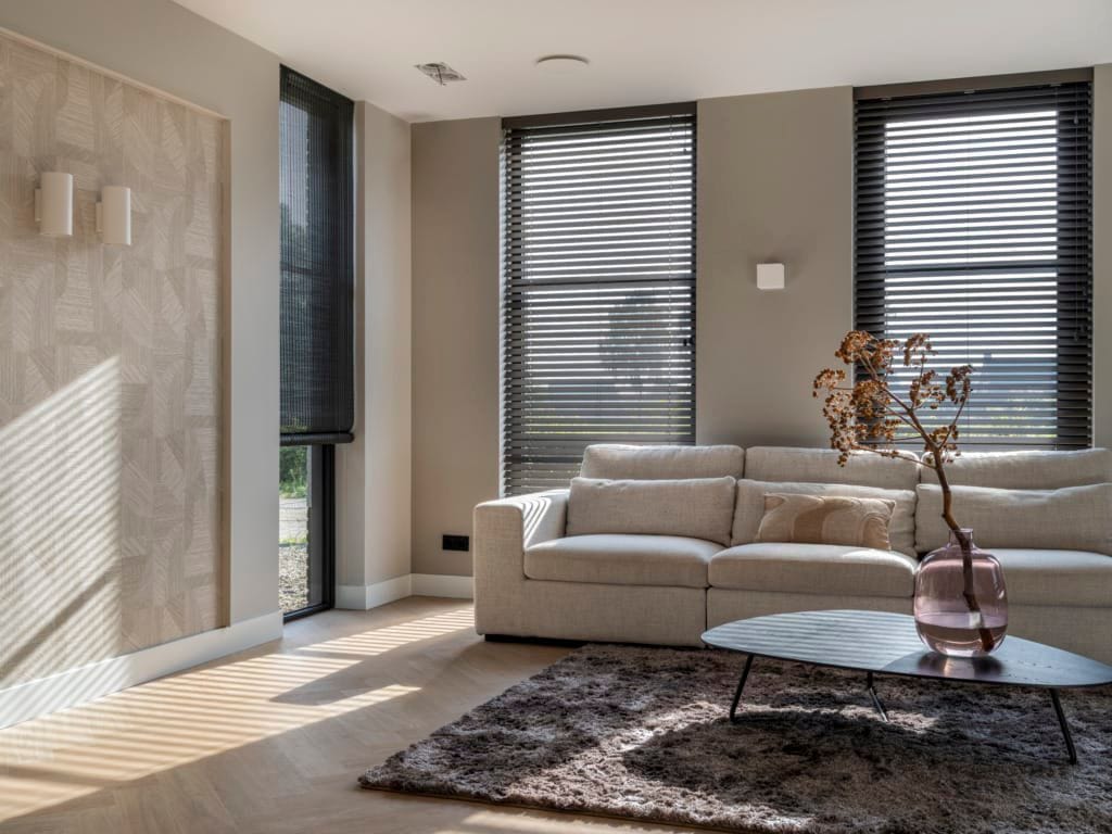 Zwarte jaloezieën in een moderne woonkamer met lichte bank