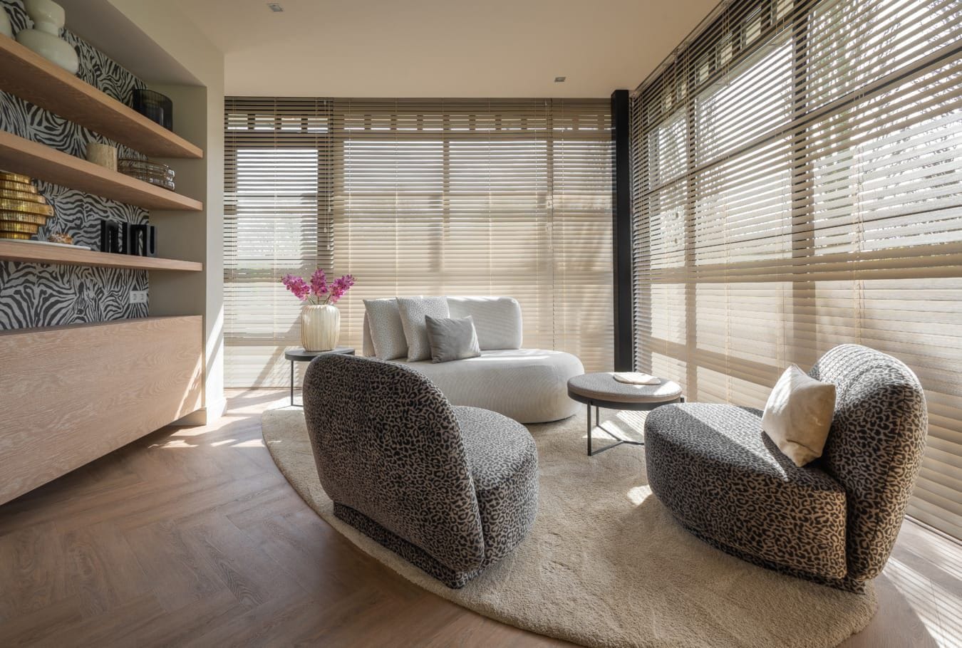 Lichte jaloezieën voor hoge ramen in een woonkamer met fauteuils