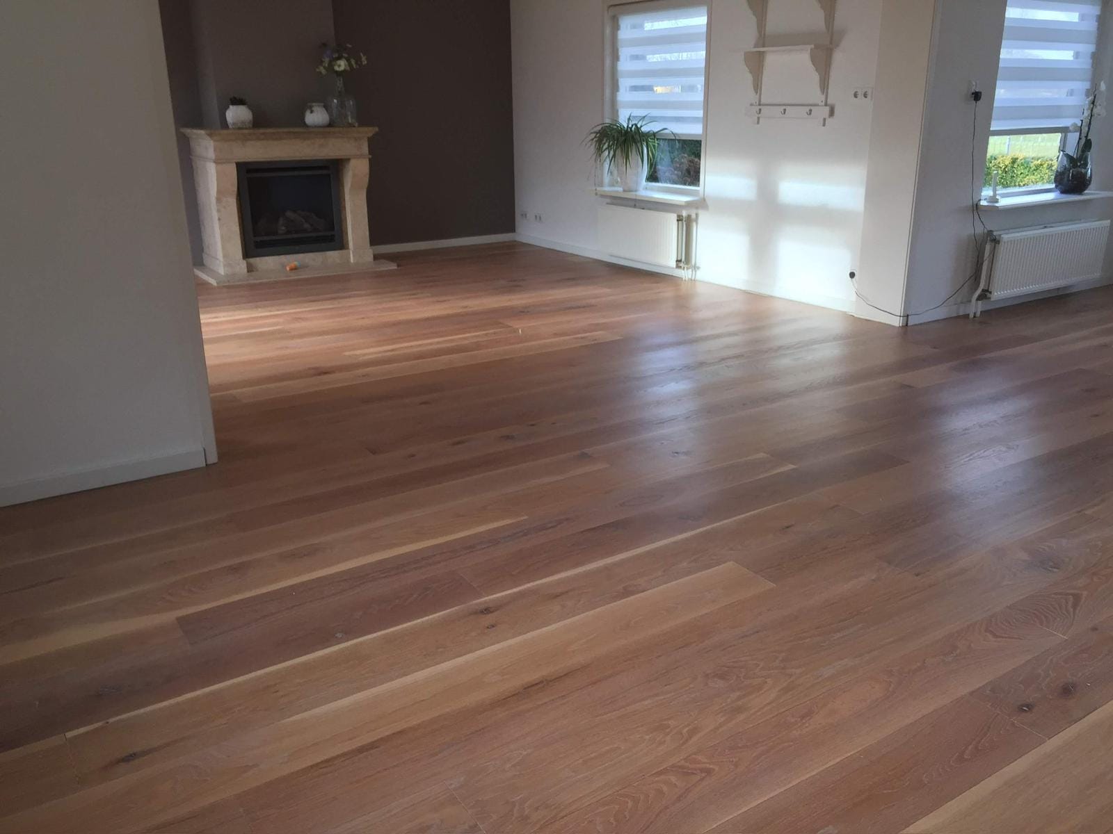 Eiken plankenvloer in een woonkamer met schouw