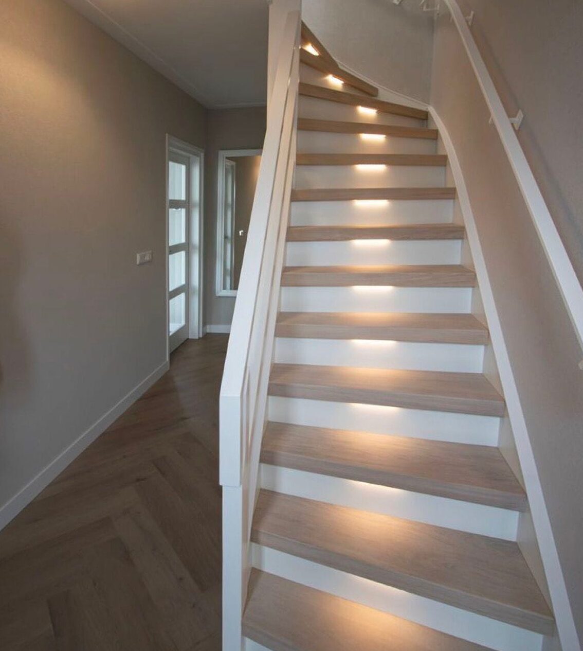 Witte trap met eiken treden en traptreeverlichting