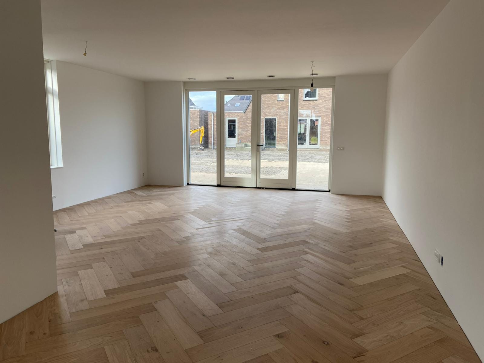 Lichte eiken visgraatvloer in een lege woonkamer