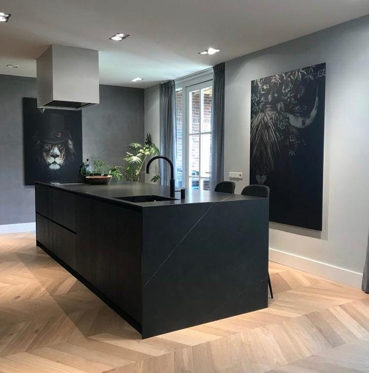 Luxe houten systeemvloer met visgraatpatroon in moderne zwarte keuken Luxe houten systeemvloer met visgraatpatroon in moderne zwarte keuken