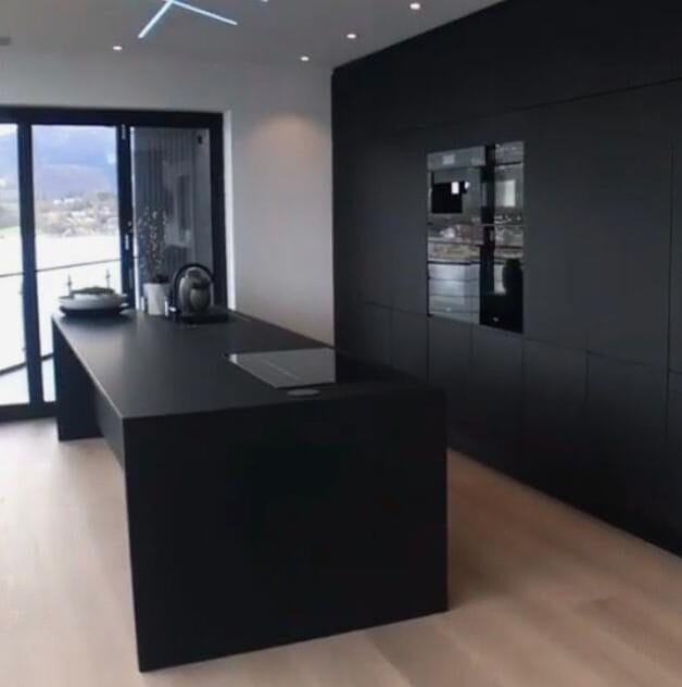 Luxe zwarte keuken met lamelparket houten vloeren